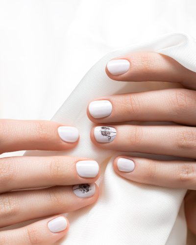 Female hands with white nail design, close up